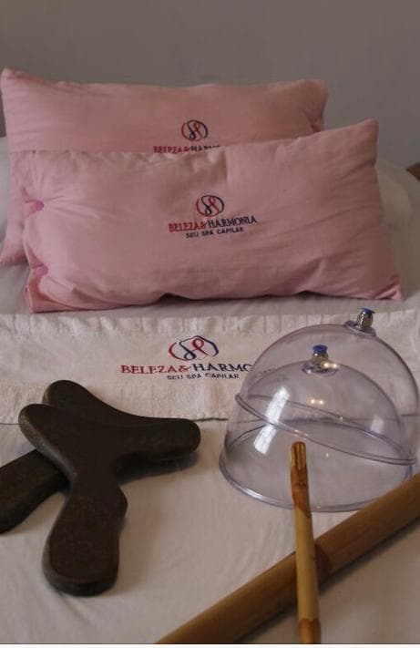 Almofadas rosas bordadas com o logo, ventosas e madeiras de massagem