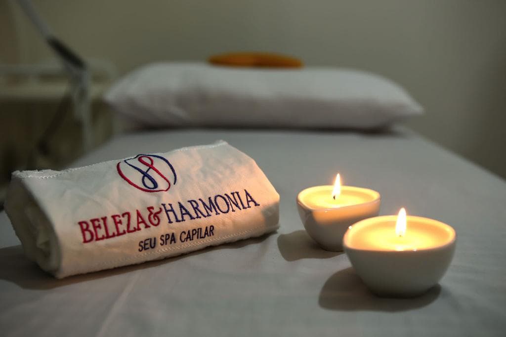 Toalha bordada Beleza & Harmonia na maca, com velas acesas