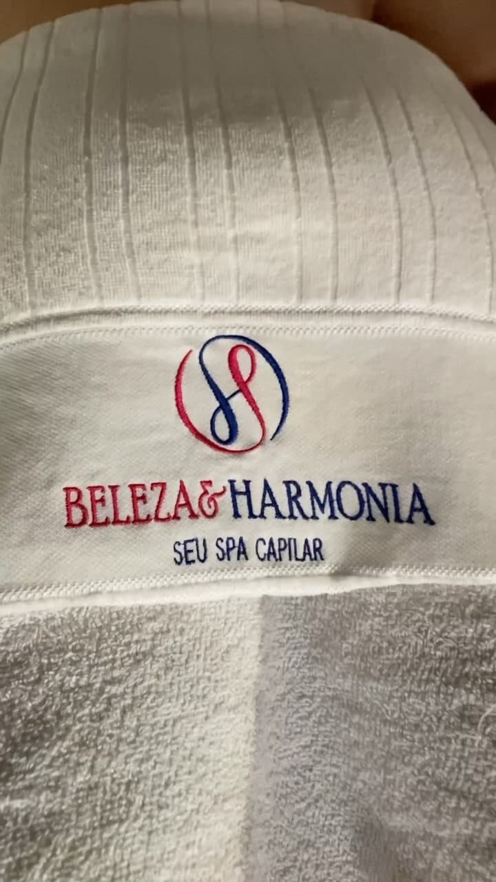 Toalha branca bordada com o logo e o nome Beleza & Harmonia, seu spa capilar